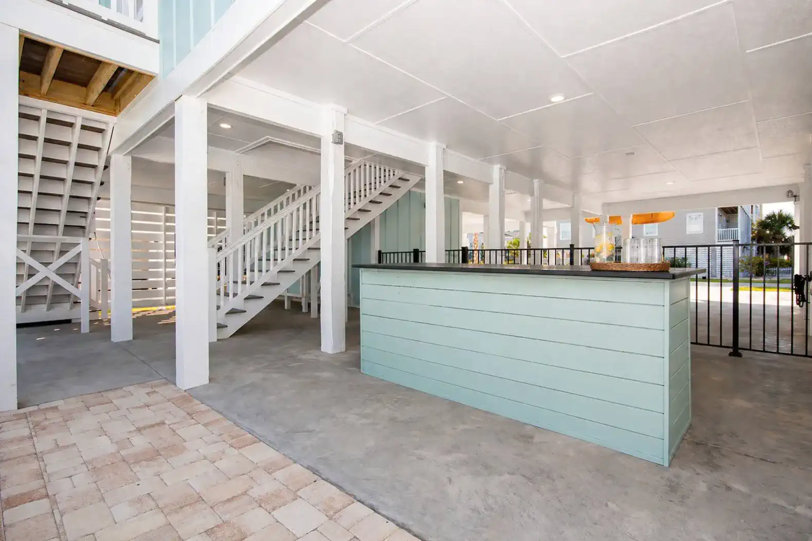 Spacious outdoor area with a bar and seating under the house