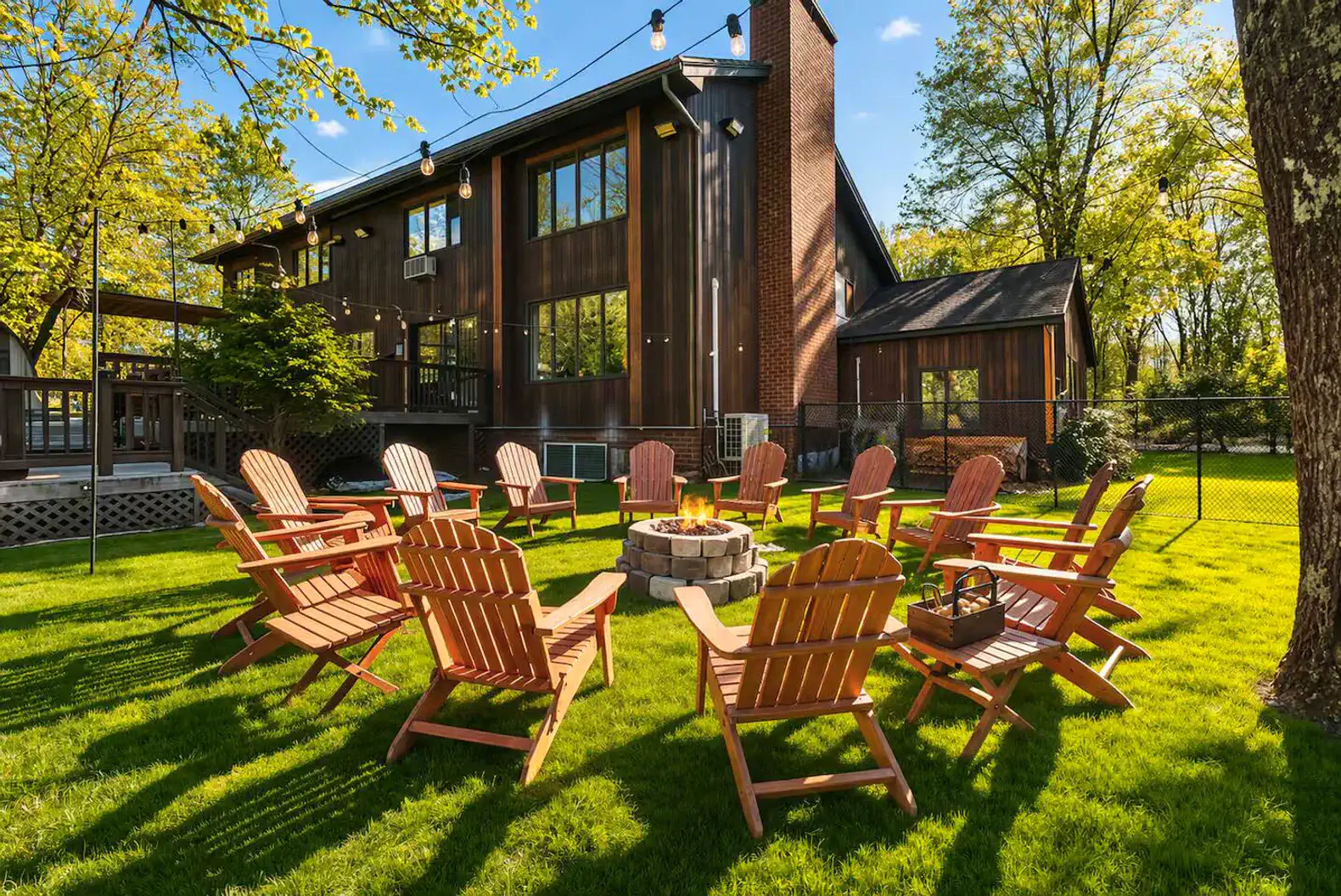 Spacious backyard oasis with fire pit, Adirondack seating & string lights