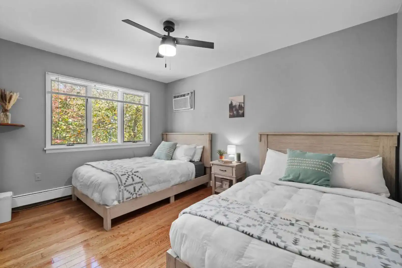 Peaceful guest room with two plush queen beds and calming forest views.