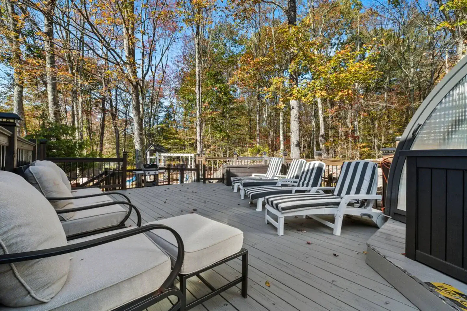 Large deck with lounge seating and direct access to the hot tub and pool area.