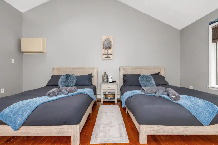 Cozy guest bedroom with two beds, soft linens, and decorative accents
