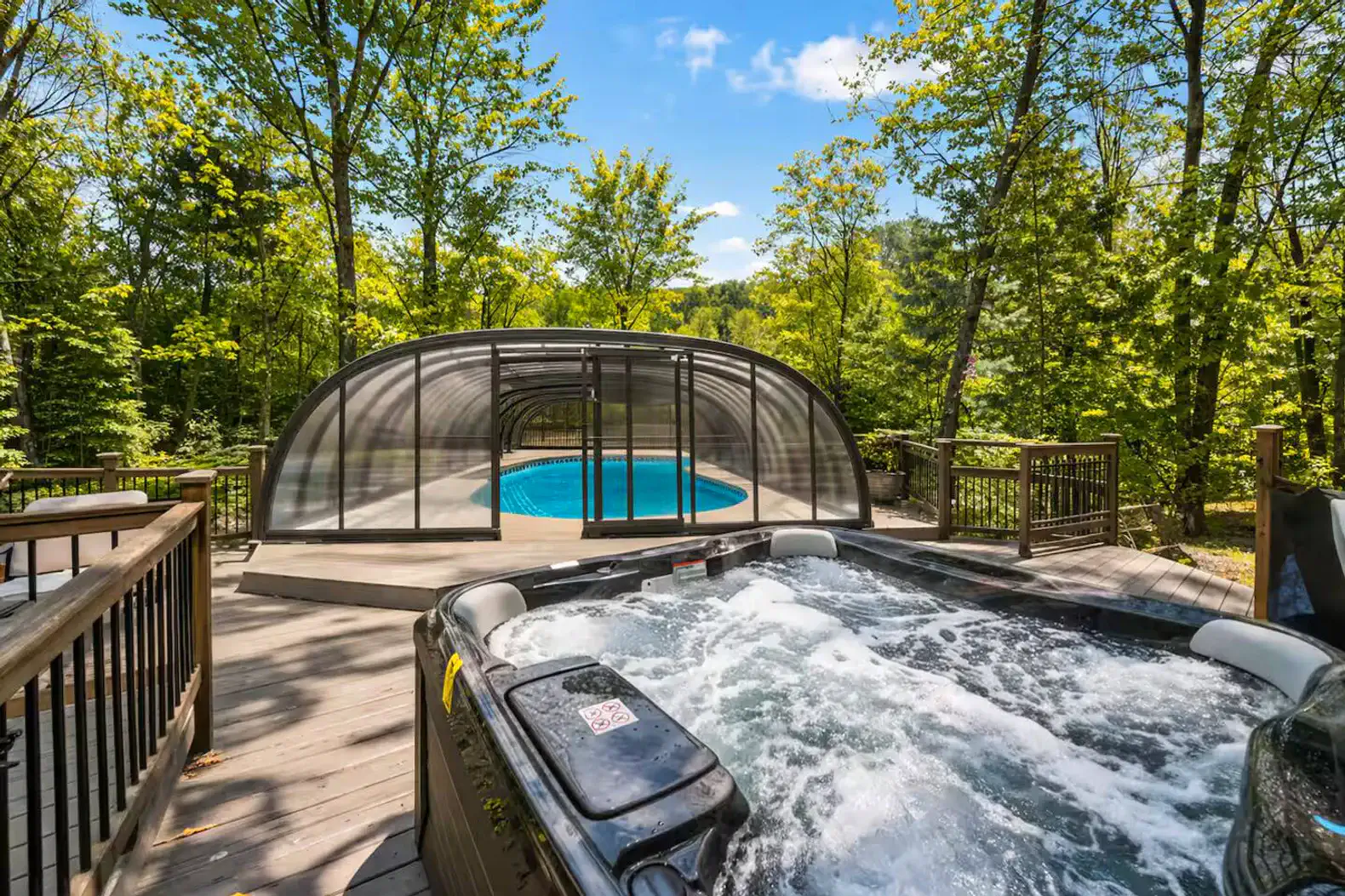 Relax in the private outdoor hot tub overlooking the trees, steps from the pool and lounge area. Perfect for unwinding after a day of adventure-ideal year-round for cozy evenings under the stars.