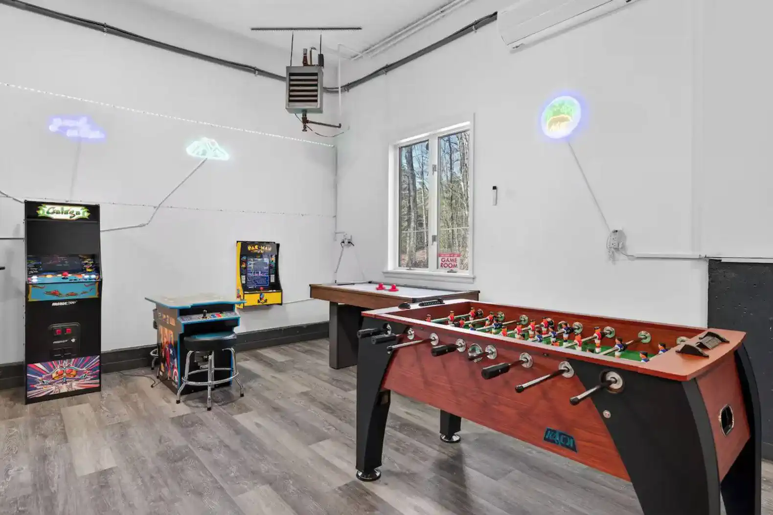 Game room featuring foosball table, arcade games, and bright wall decor