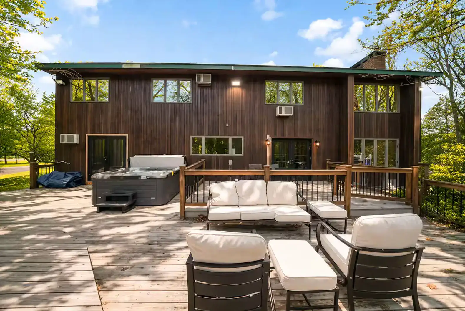 Large deck with lounge seating and direct access to the hot tub and pool area.