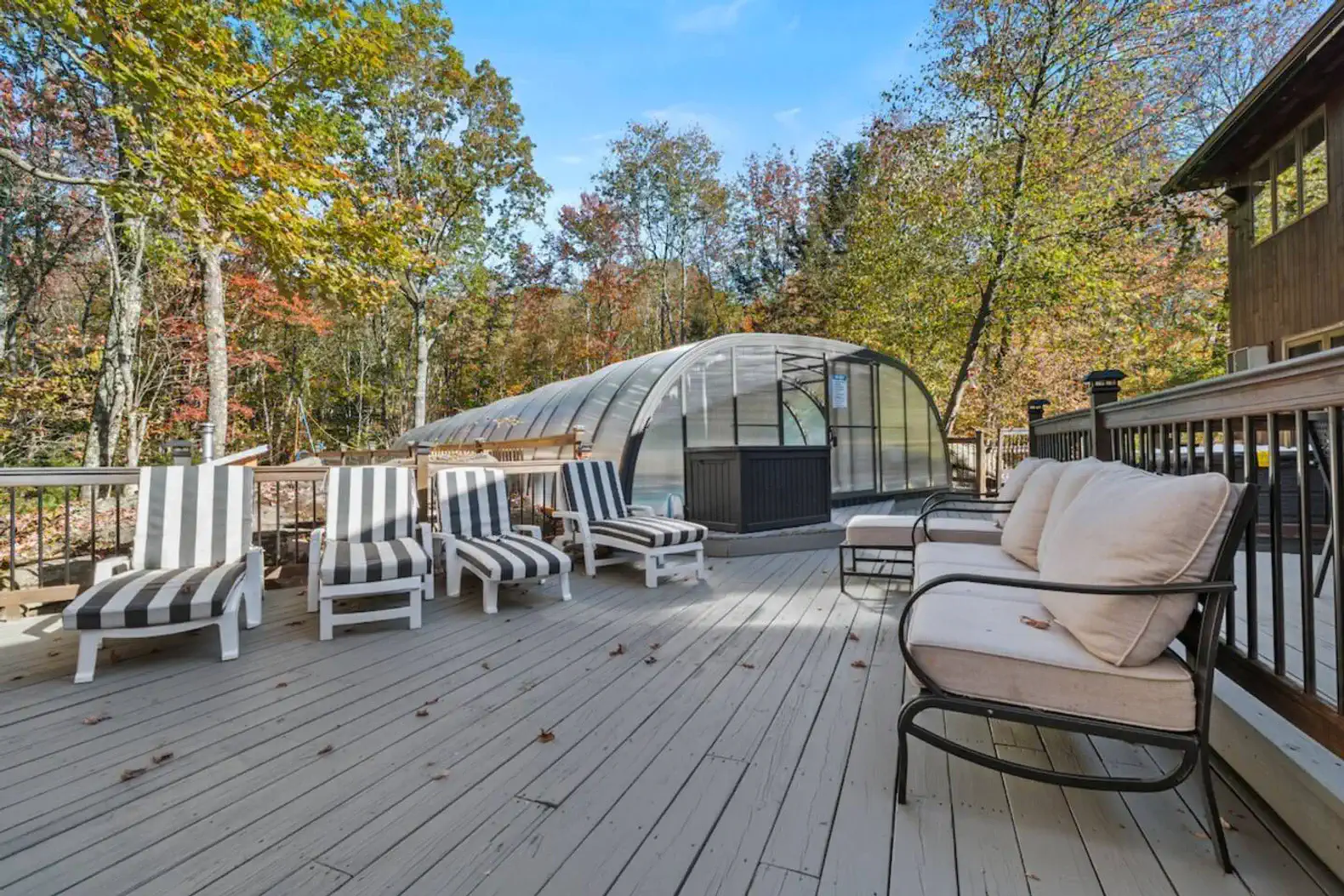 Large deck with lounge seating and direct access to the hot tub and pool area.