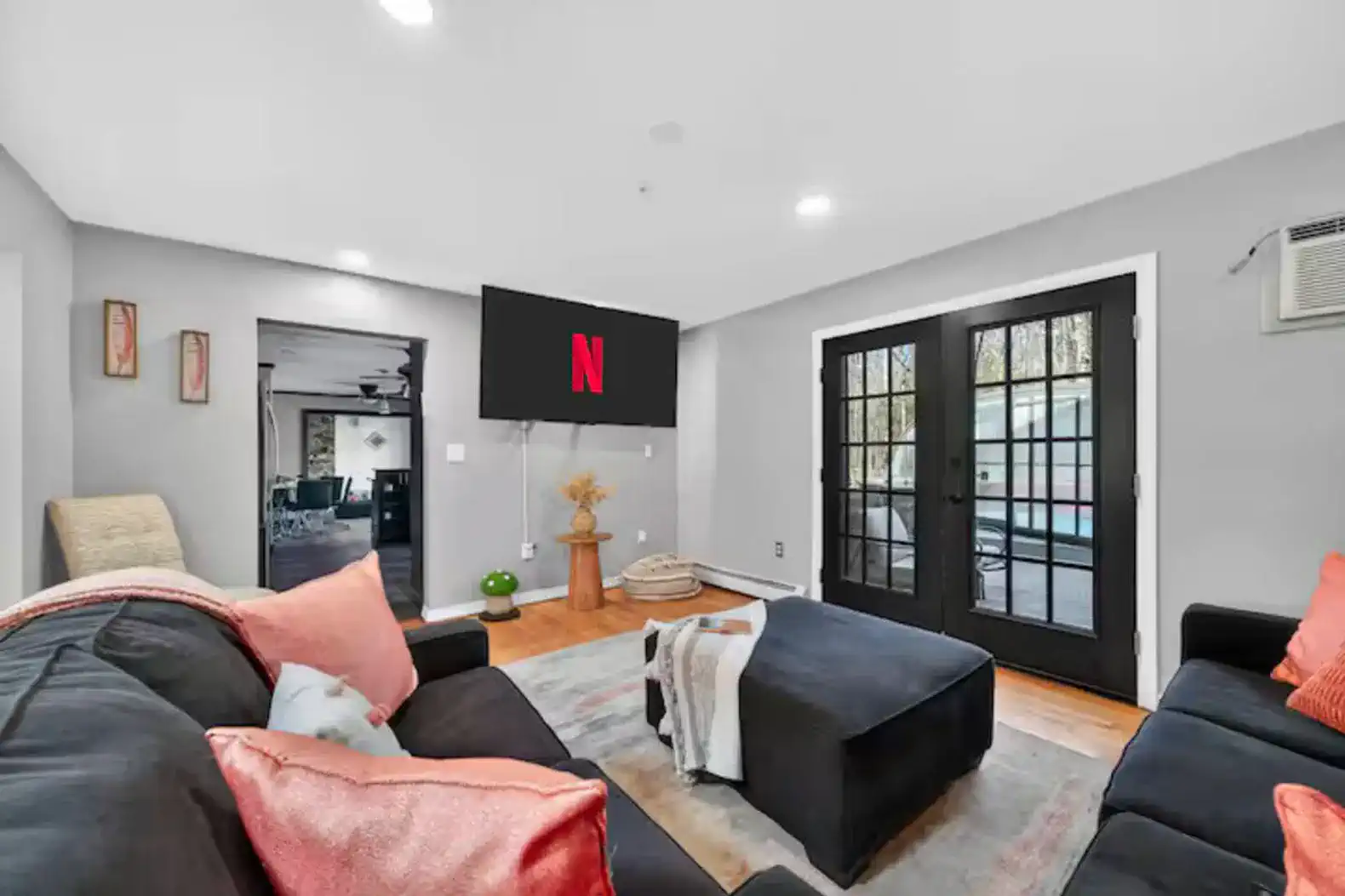 Modern lounge with big sectional, streaming TV, and deck access
