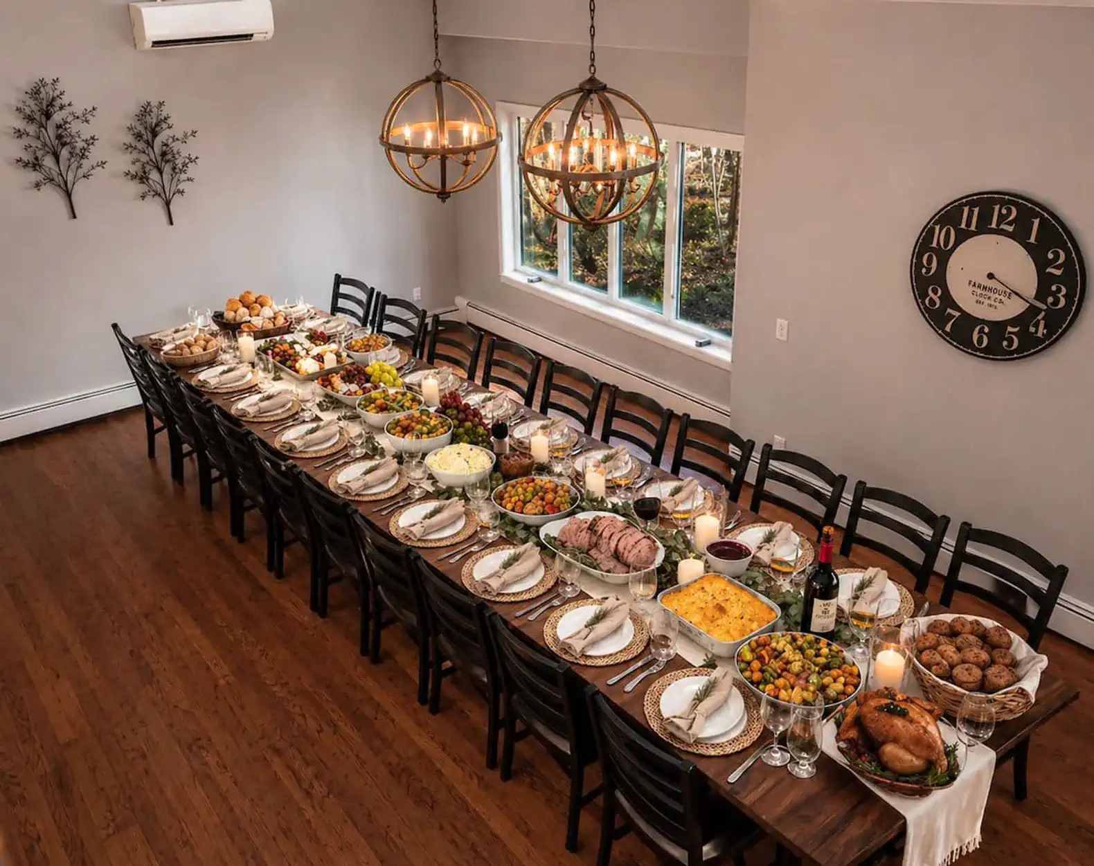 Long dining table set with a variety of dishes and candles, surrounded by chairs