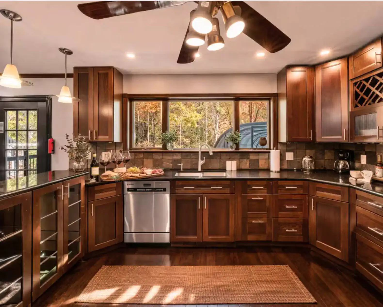 Modern full kitchen with rich wood cabinetry, granite counters, and bar seating for casual dining