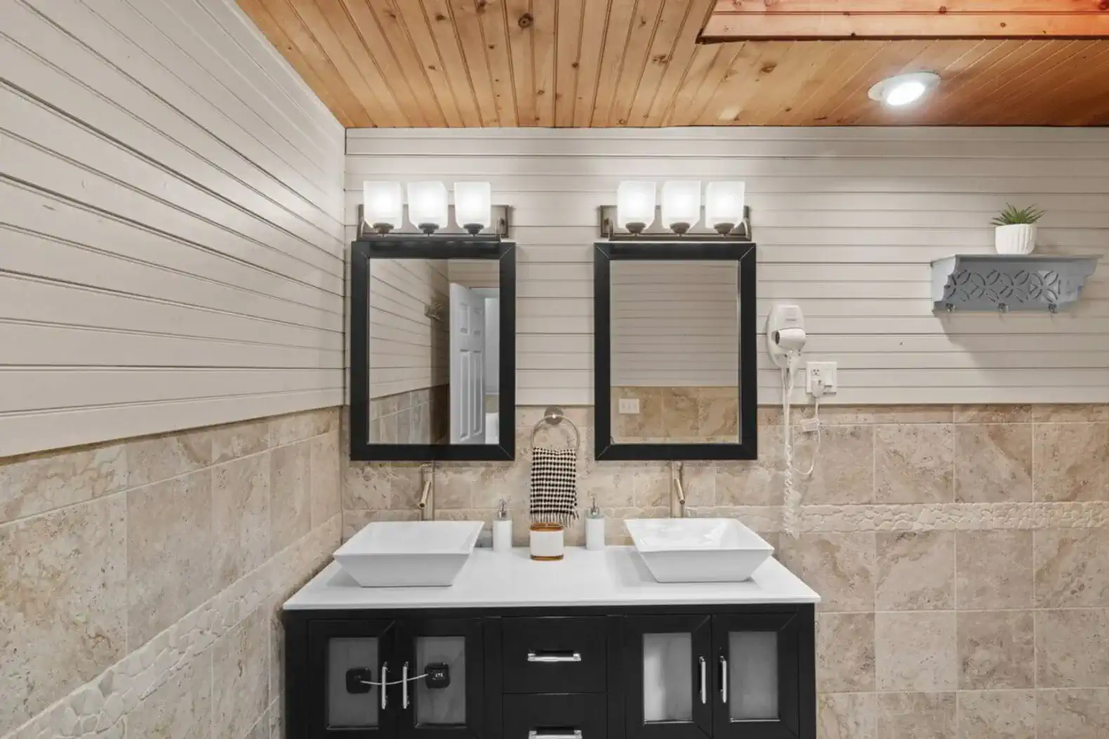 Warm tile finishes and wood-accented ceilings create a relaxing, spa-like retreat.