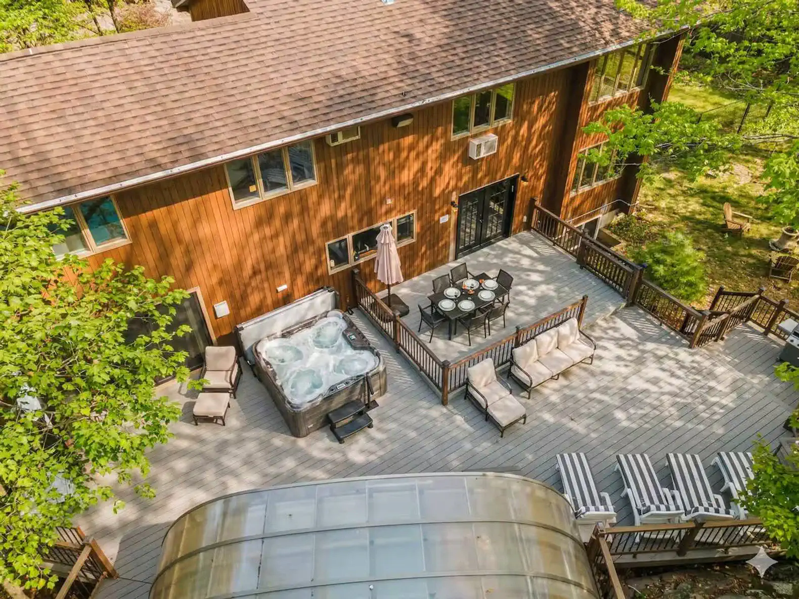 Spacious deck layout featuring both the hot tub and outdoor dining area for seamless entertaining.