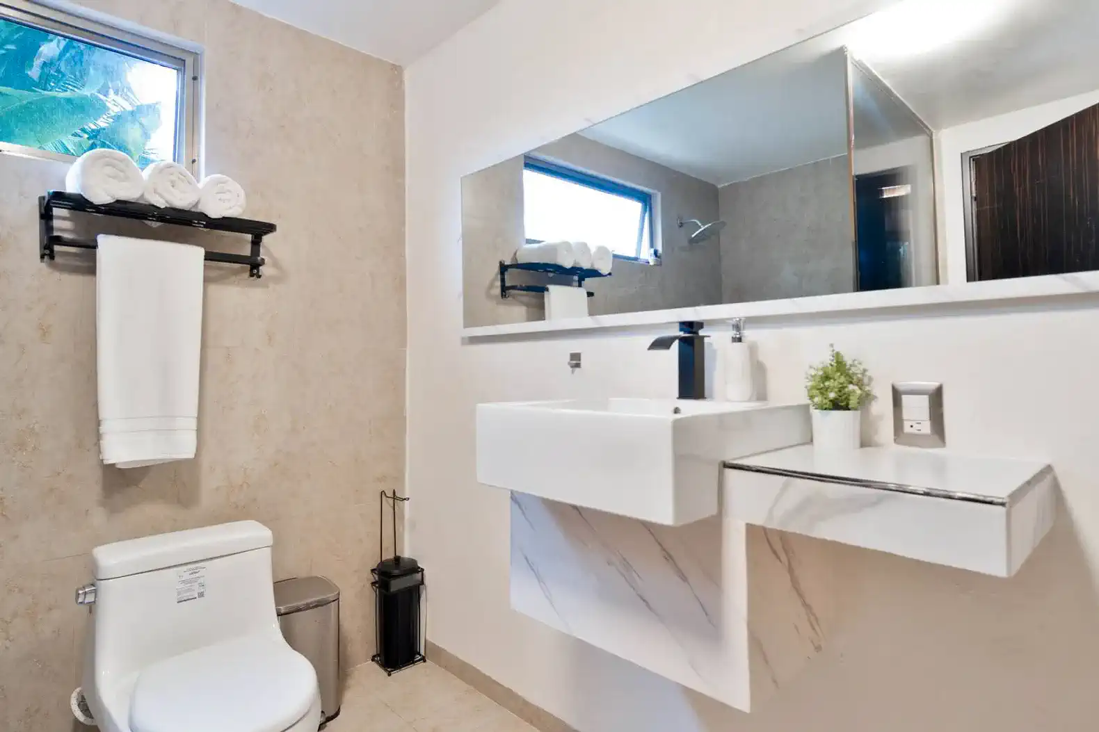 Baño moderno con lavabo elegante y toallas blancas