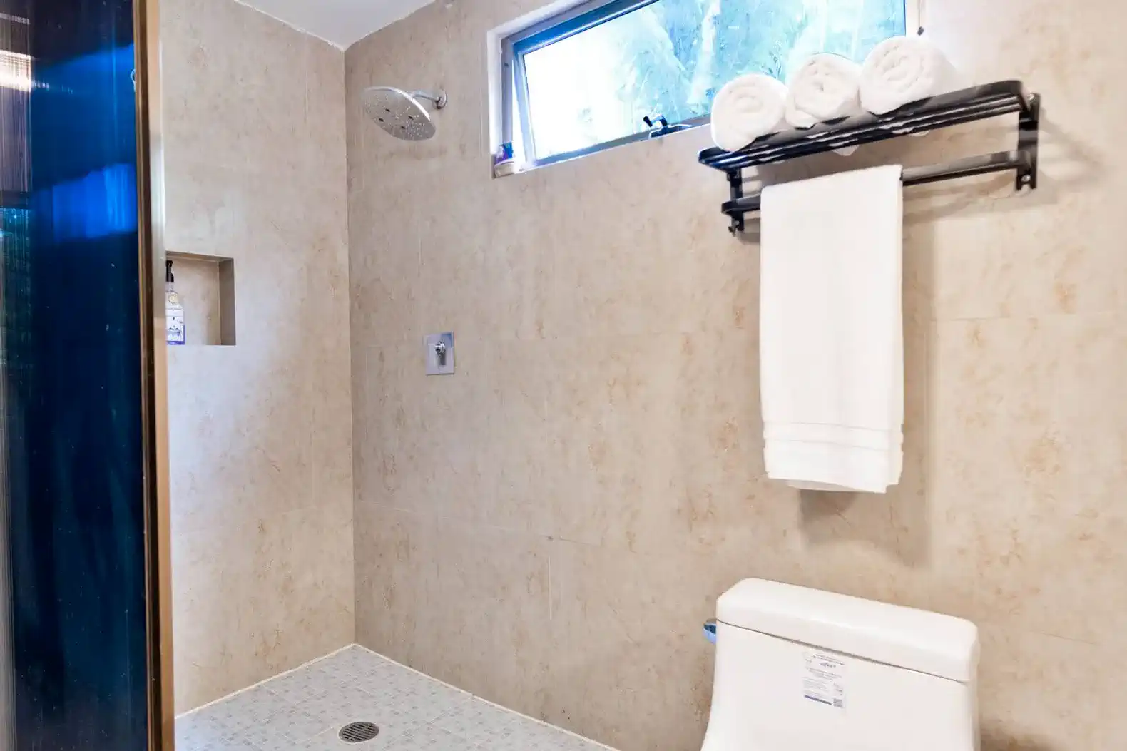 Baño moderno con ducha amplia y toallas blancas