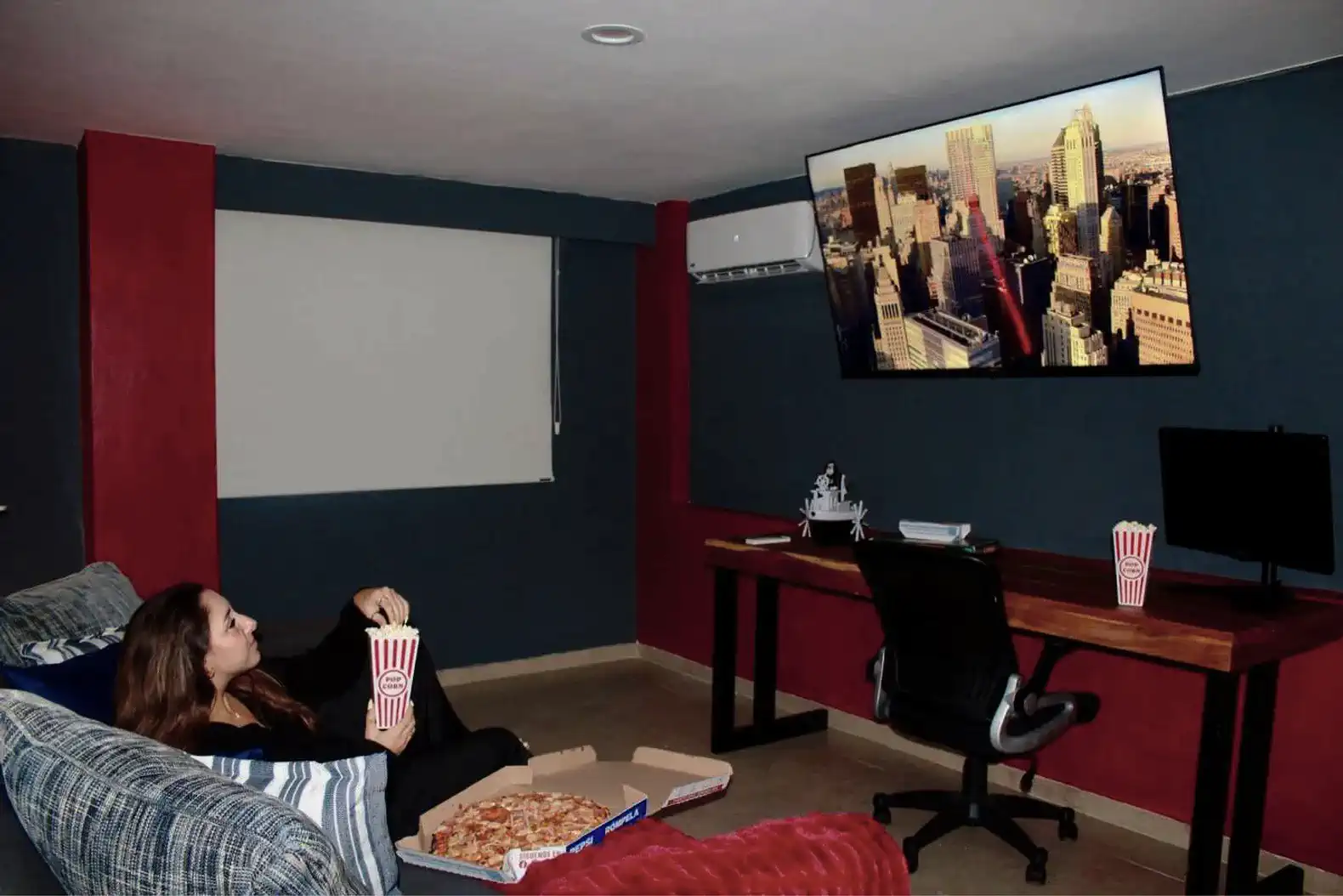 Sala de estar con sofá cómodo, televisor grande y mesa de trabajo