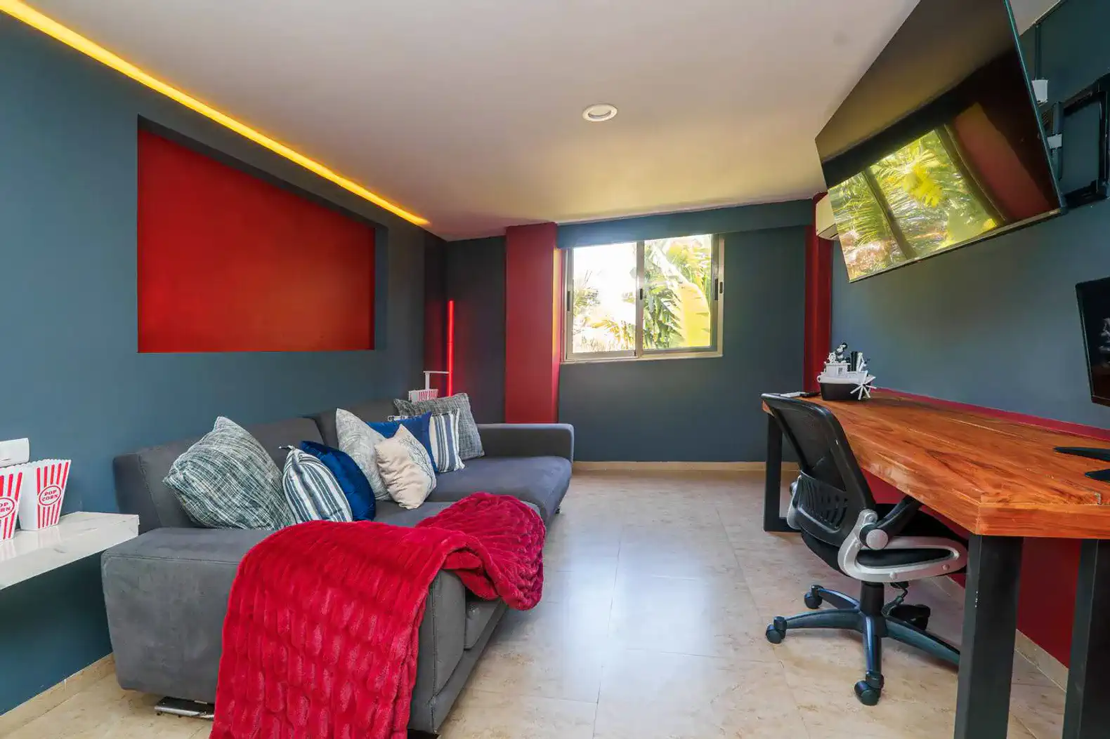Sala de estar moderna con sofá cómodo, escritorio y ventana luminosa