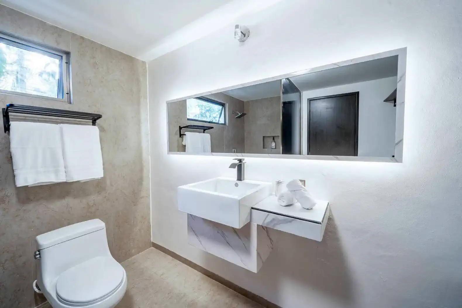 Baño moderno con lavabo elegante y espejo iluminado
