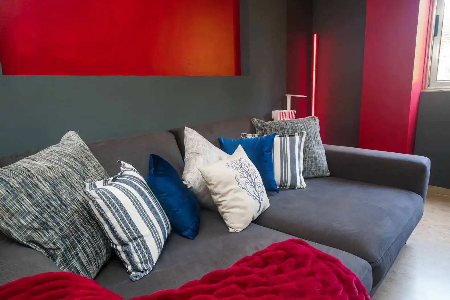 Sofá moderno con cojines decorativos en tonos azules y grises