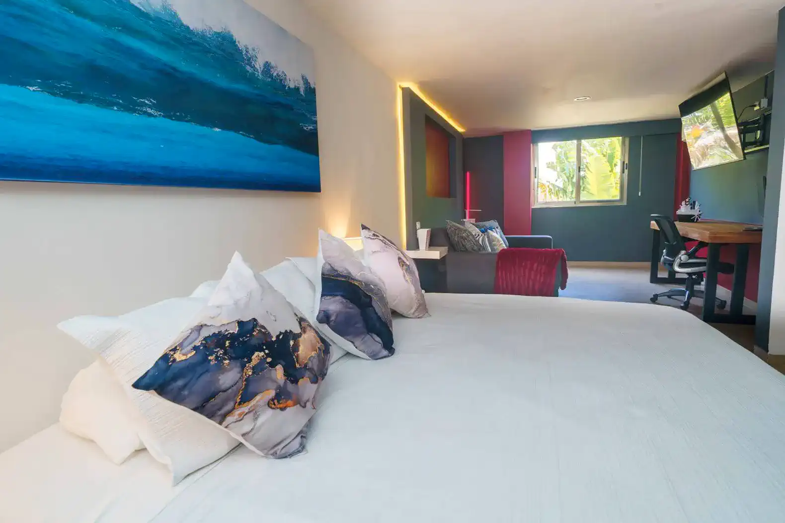 Habitación principal con cama grande, decoración moderna y vista a la sala de estar
