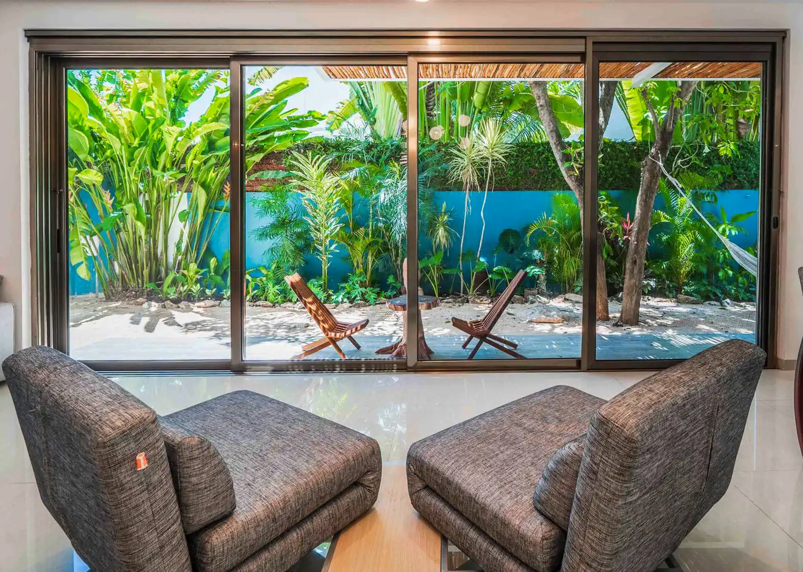 Seating area with two chairs overlooking a lush garden and patio