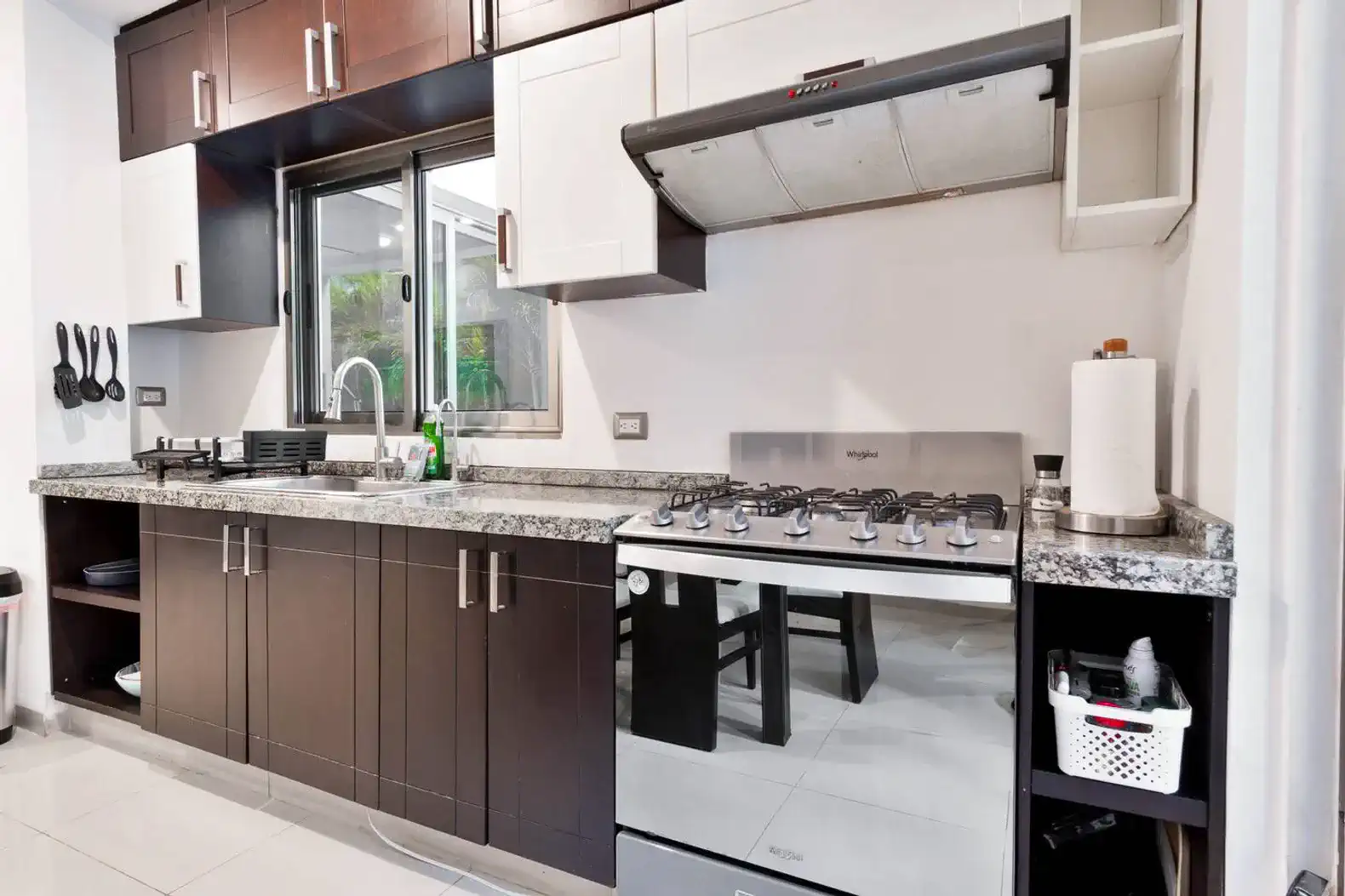 Cocina moderna con encimeras de granito y electrodomésticos de acero inoxidable