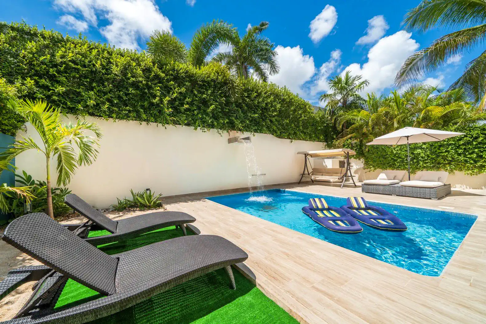 Private heated pool surrounded by lush greenery and lounge chairs