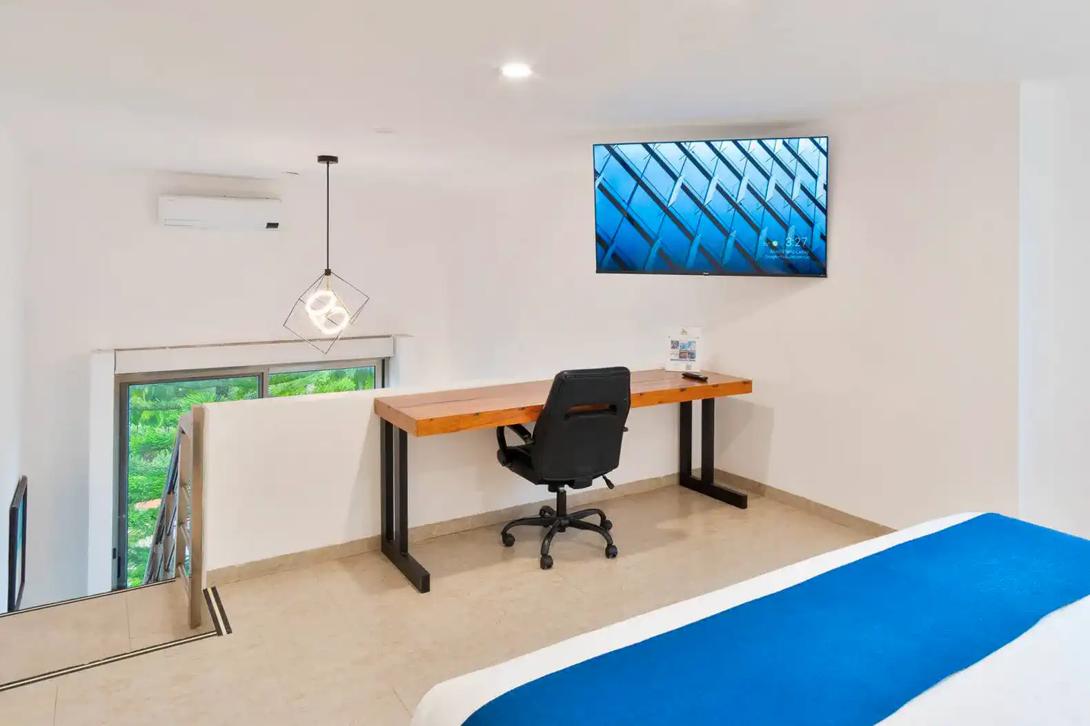 Habitación moderna con escritorio, televisor y vista al exterior