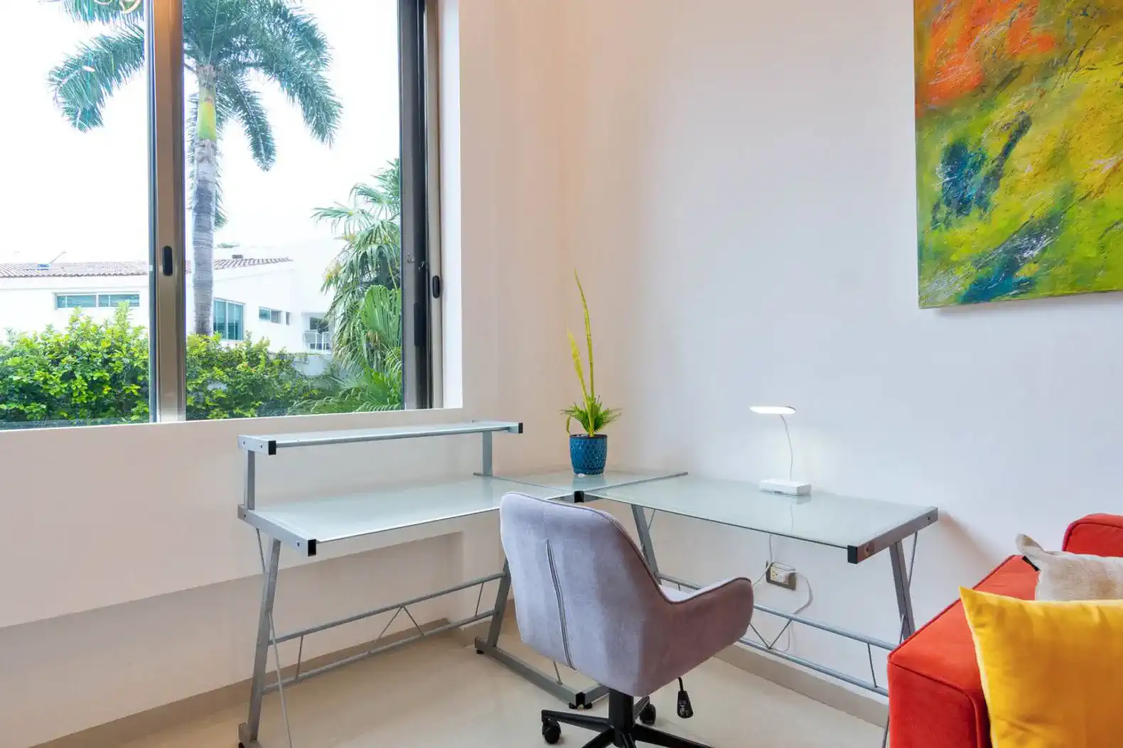 Escritorio moderno junto a una ventana con vista a la vegetación exterior