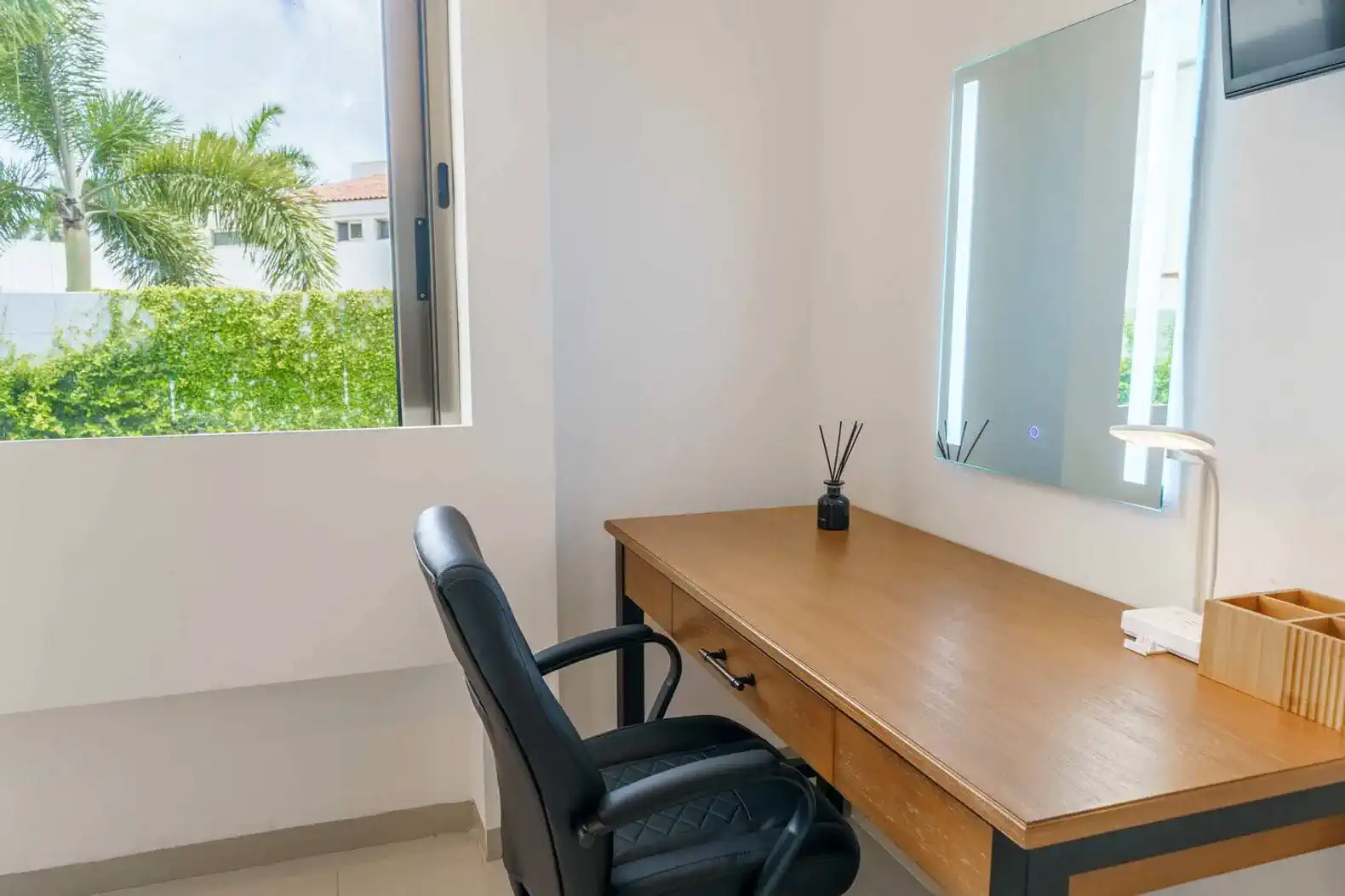 Escritorio moderno con silla de oficina y ventana que ofrece vistas al exterior