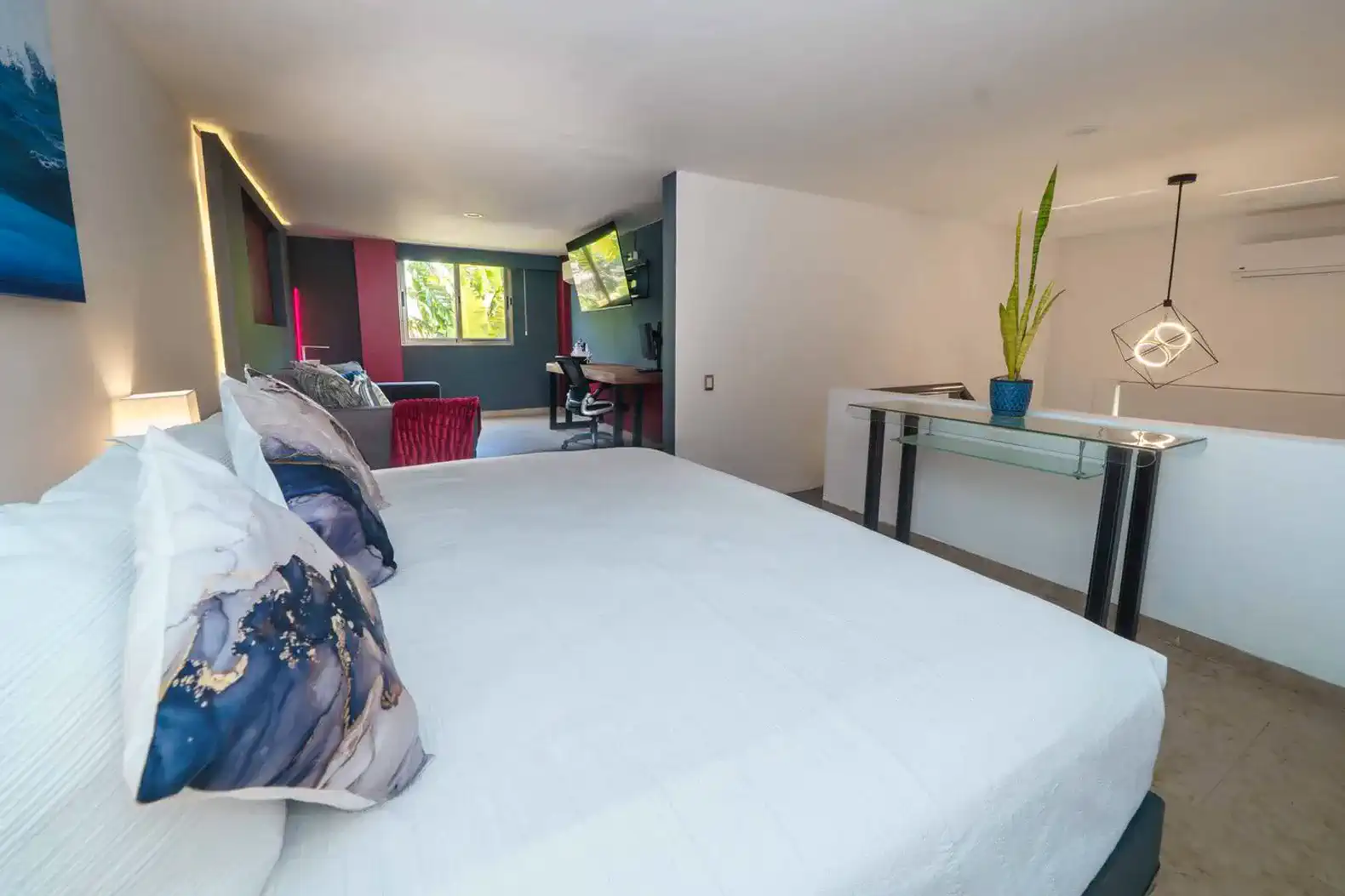 Habitación moderna con cama grande, escritorio y área de estar