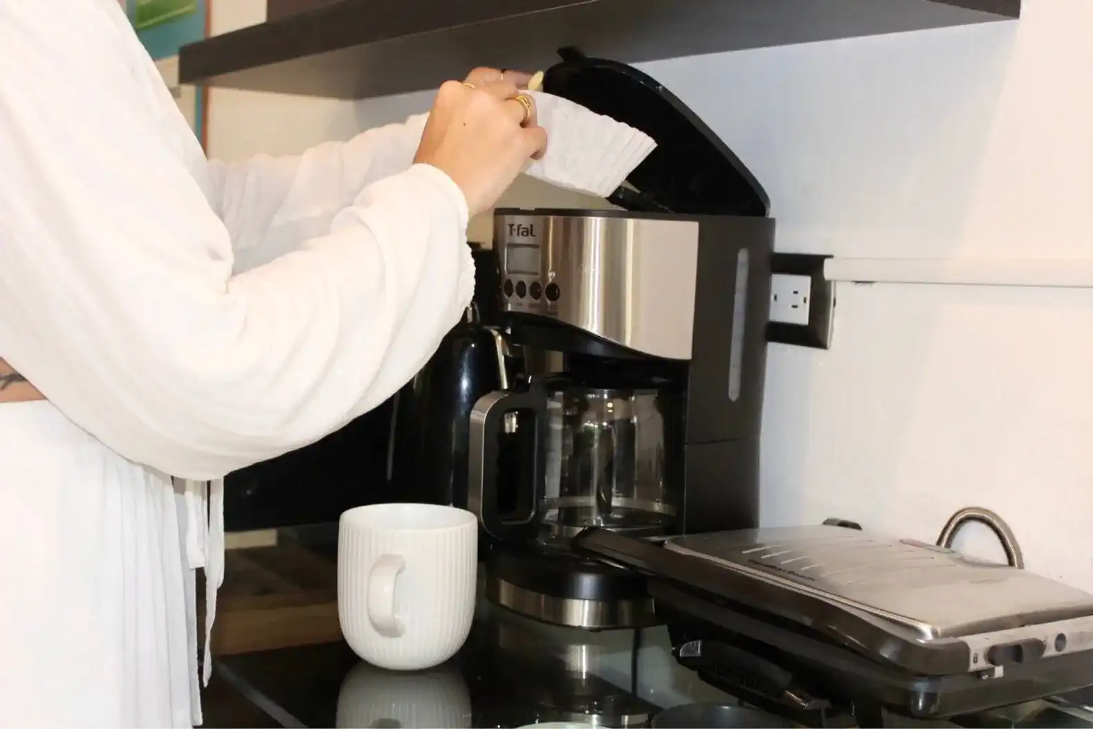Máquina de café en la cocina con una persona preparando café