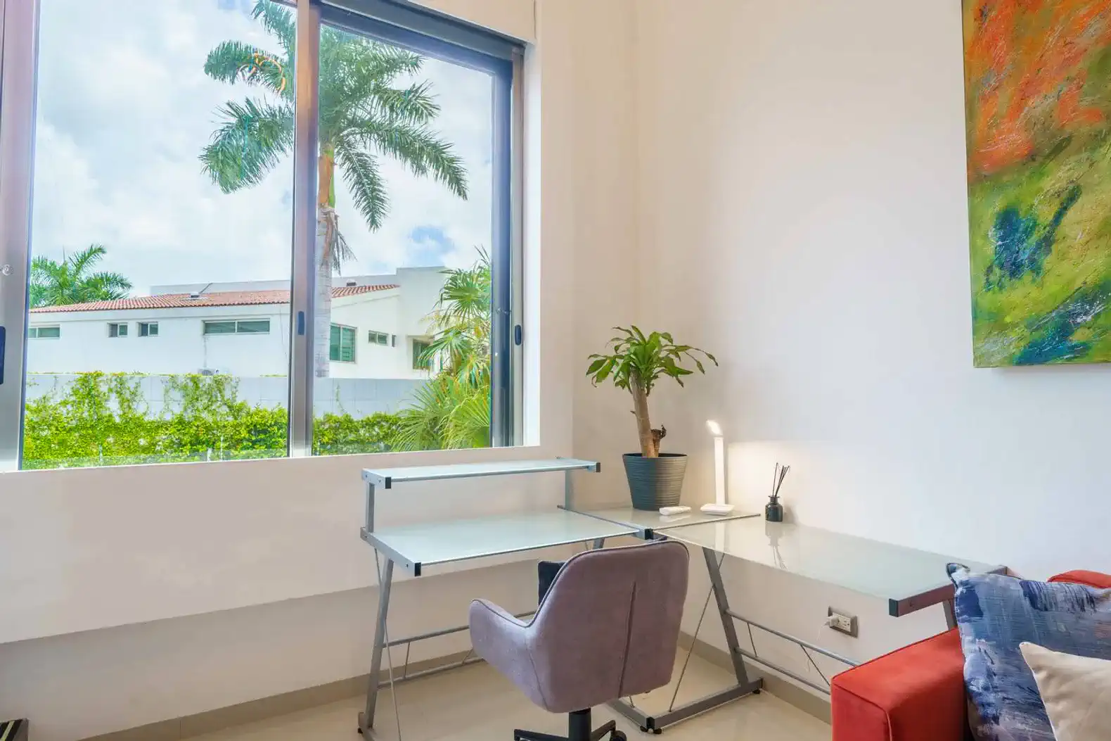 Escritorio moderno junto a una ventana con vista a la vegetación exterior