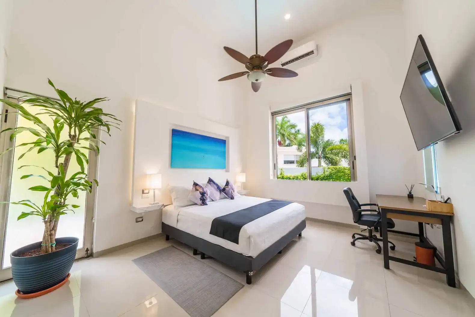 Habitación luminosa con cama king, escritorio y vista al jardín