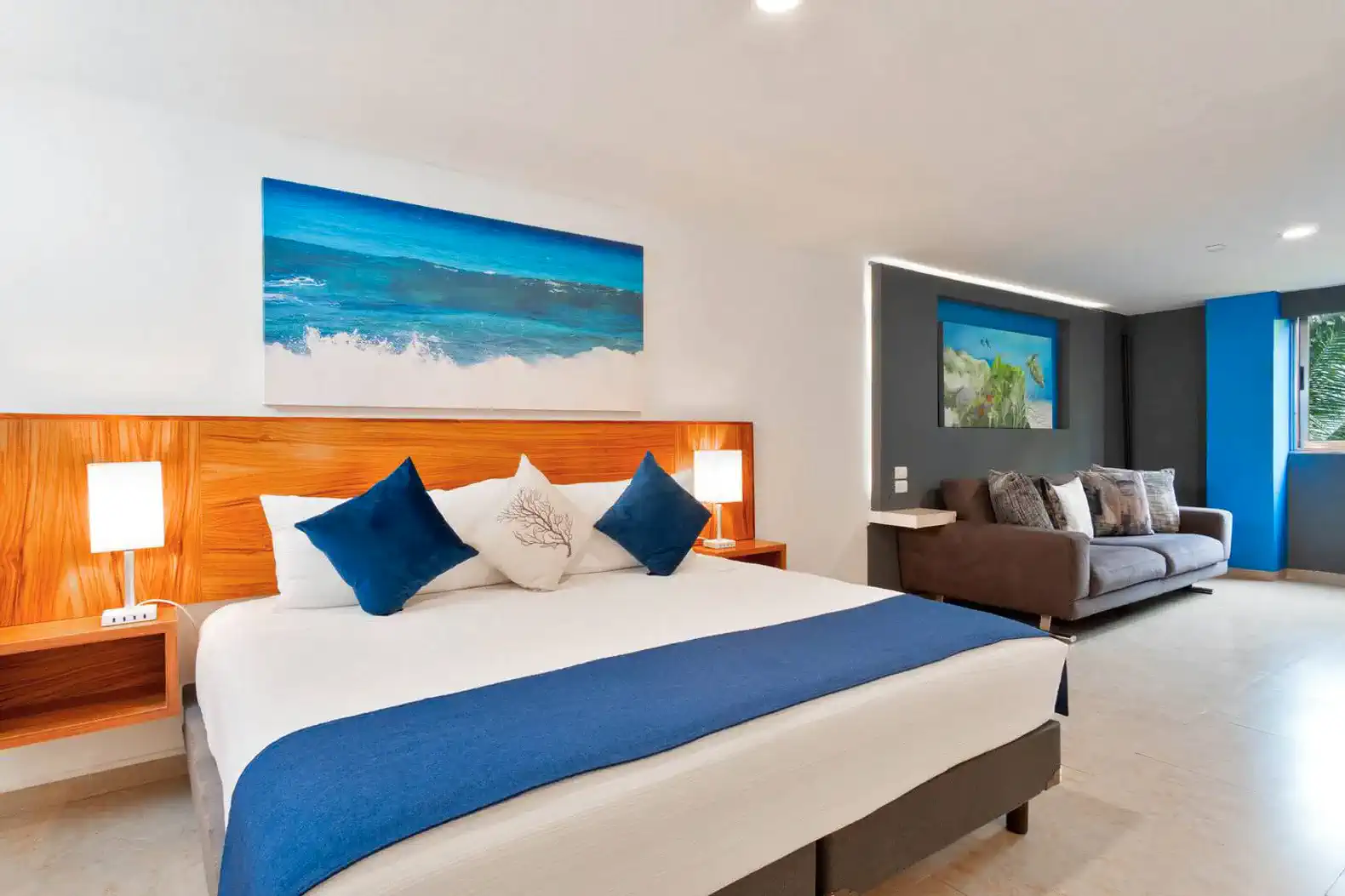 Habitación con cama grande, decoración moderna y sofá, ideal para relajarse