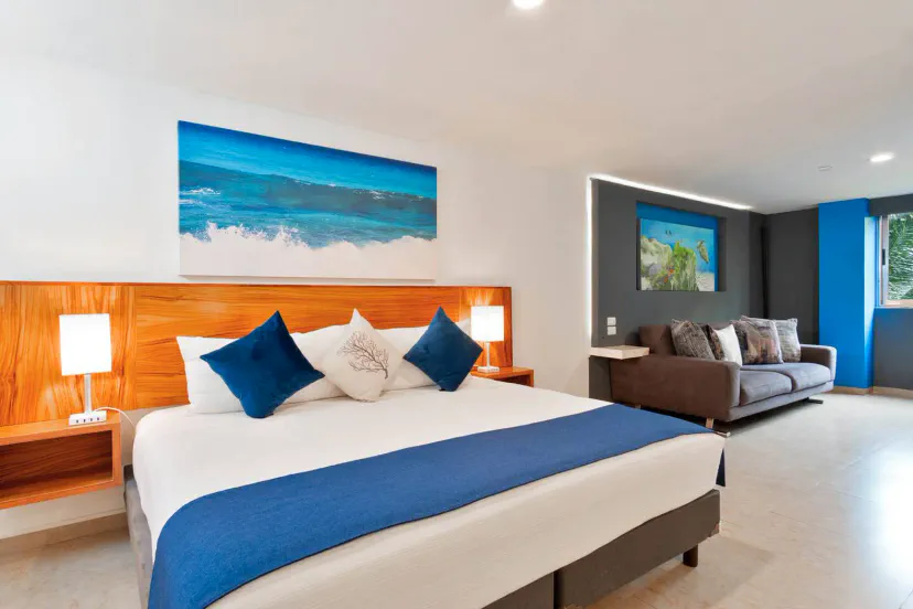 Room with a large bed, modern decor, and a sofa, perfect for relaxing.