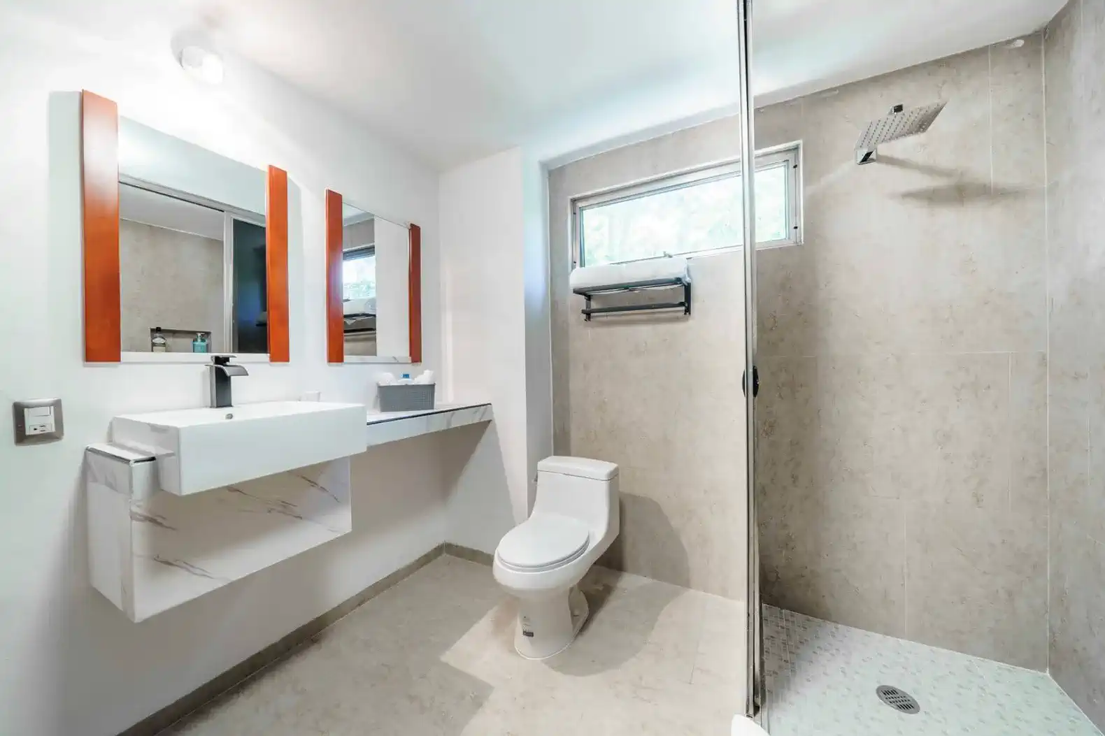 Baño moderno con ducha, lavabo elegante y espejo doble