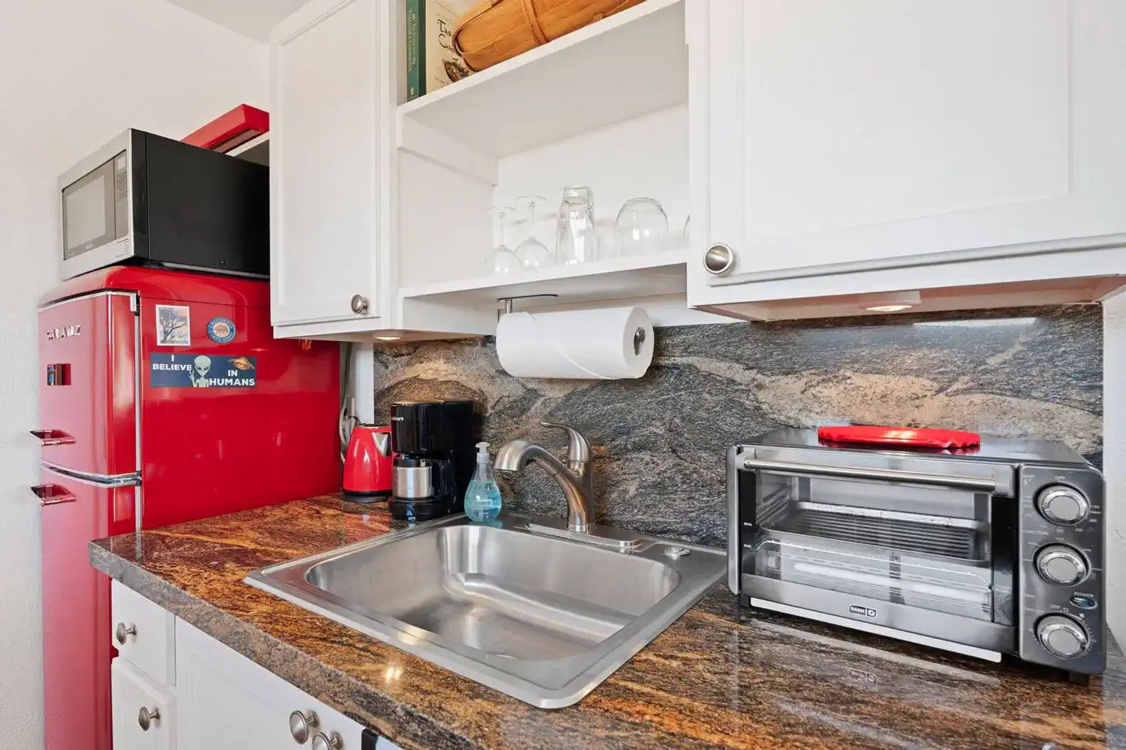 Compact kitchen with red refrigerator, sink, and countertop appliances
