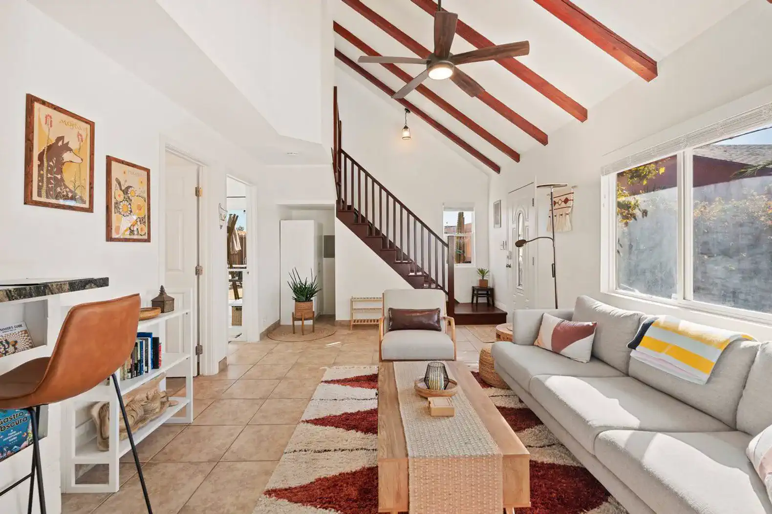 Bright living room with high ceilings, cozy seating, and decorative art