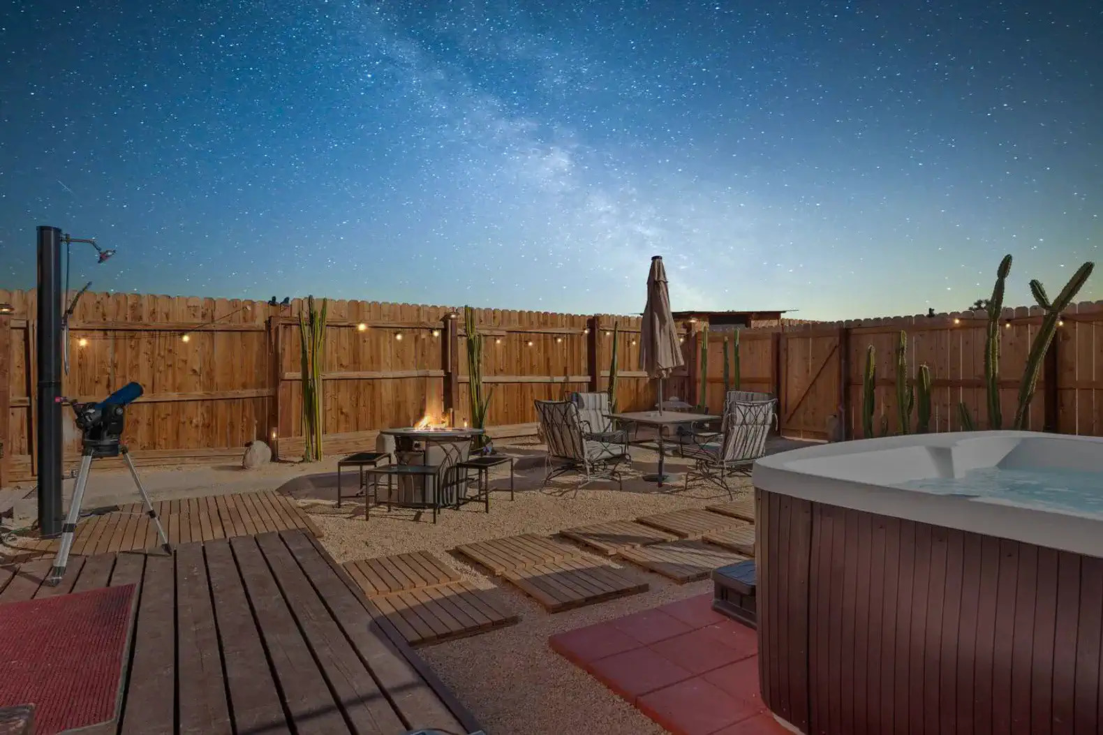 Outdoor area with a hot tub, seating, and starry night sky