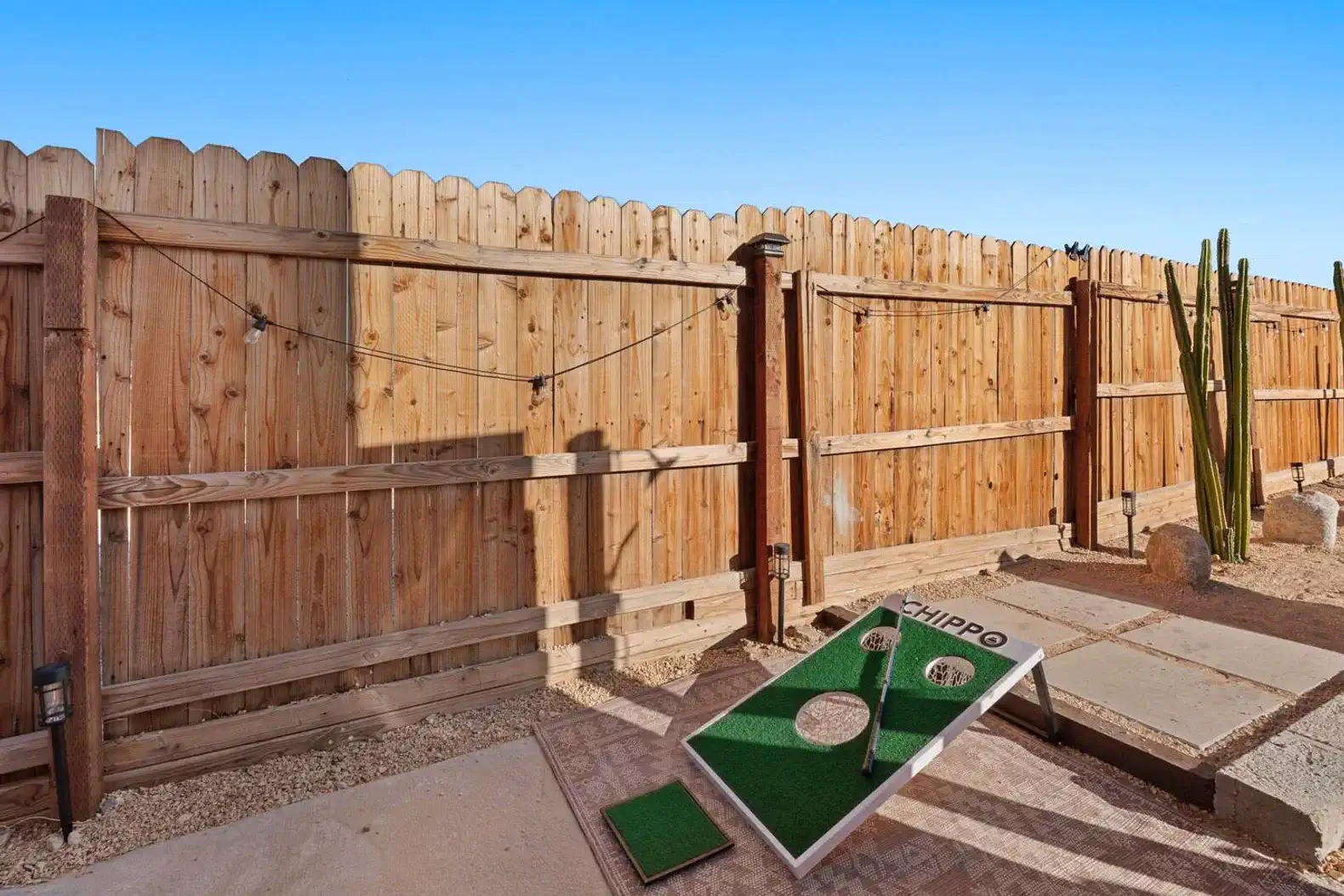 Outdoor area with a mini golf setup and wooden fence