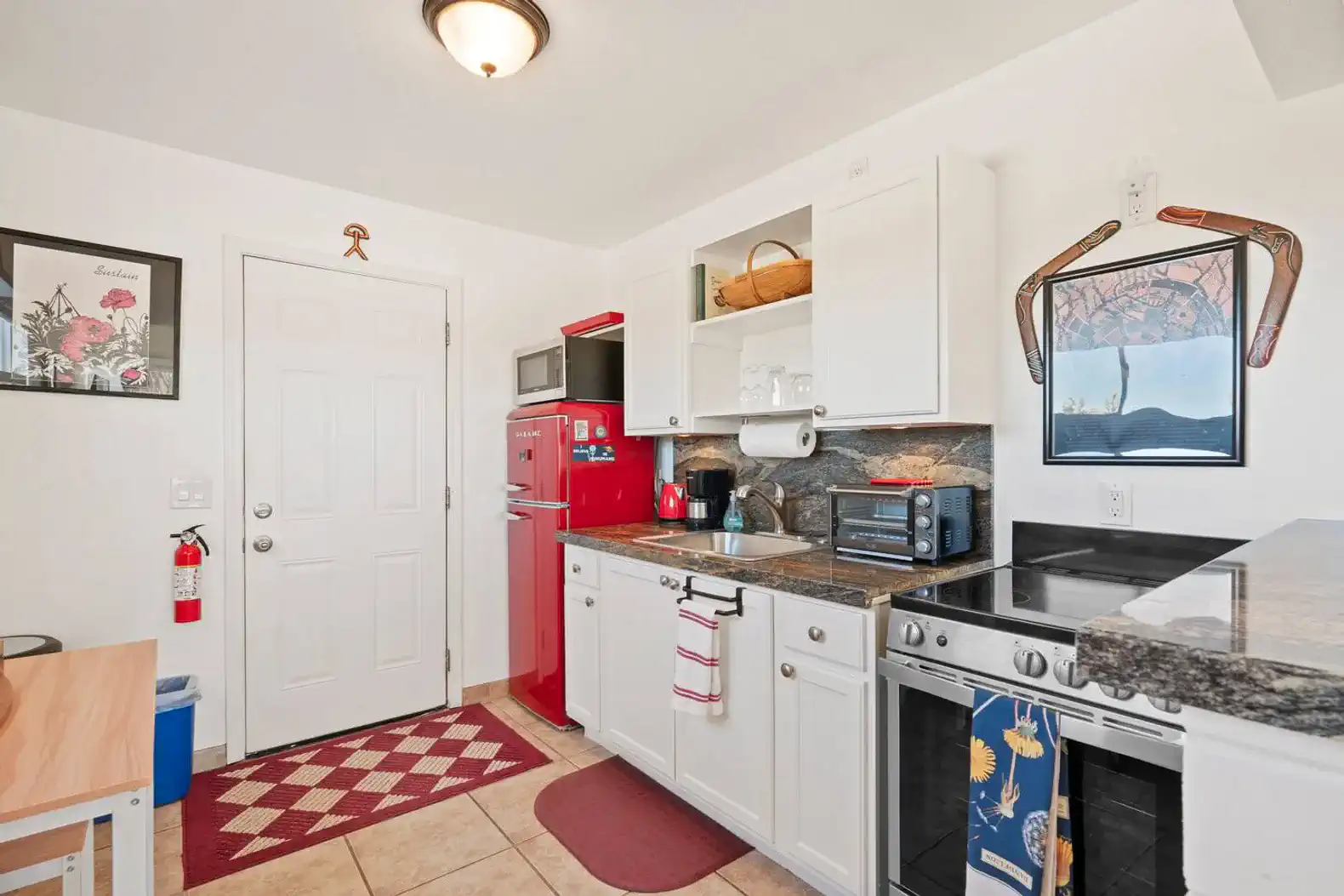 Cozy kitchen with red appliances, granite countertops, and ample storage
