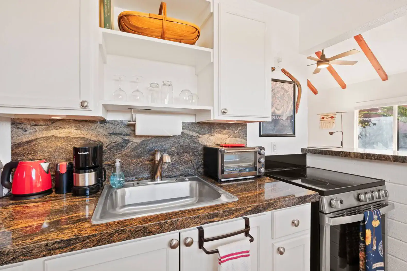 Modern kitchen with granite countertops, stainless steel appliances, and bright decor