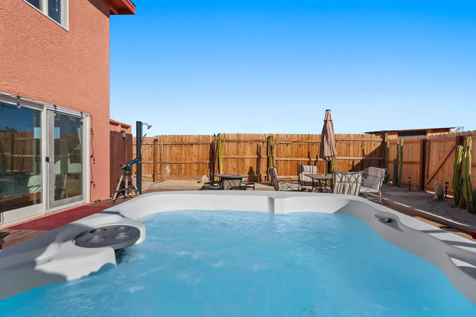 Relaxing hot tub area with outdoor seating and a fenced yard
