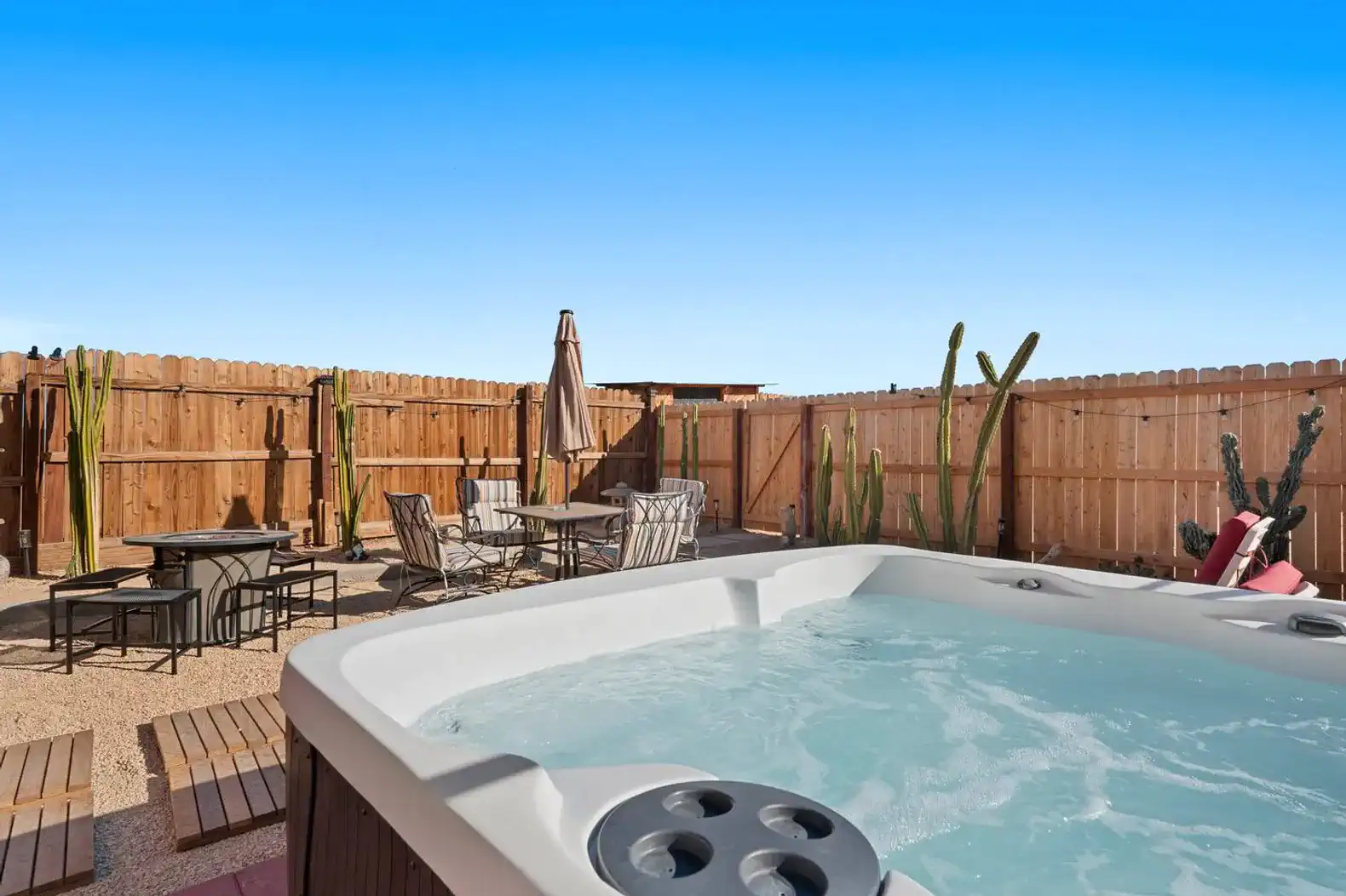 Hot tub surrounded by outdoor seating and desert landscaping