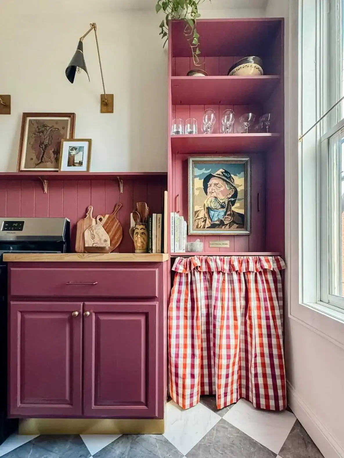 Charming kitchen corner with burgundy cabinetry and a decorative curtain