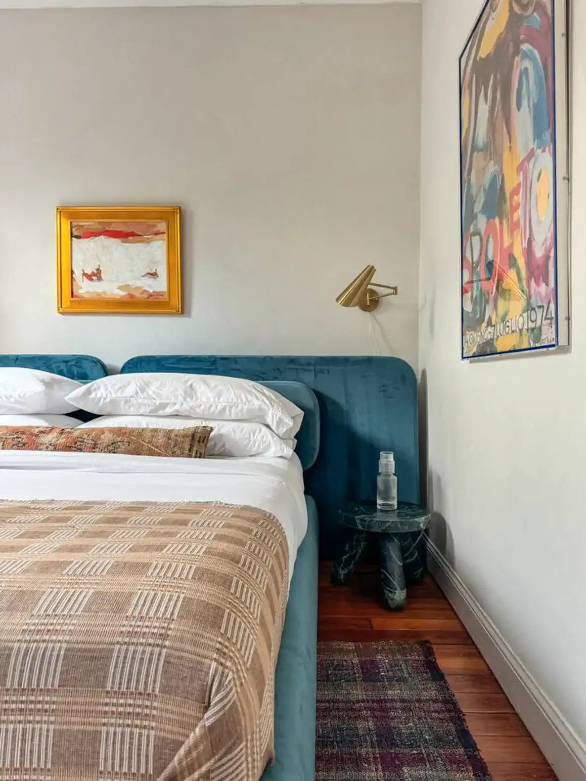 Cozy master bedroom with a blue bed, artwork, and a stylish nightstand