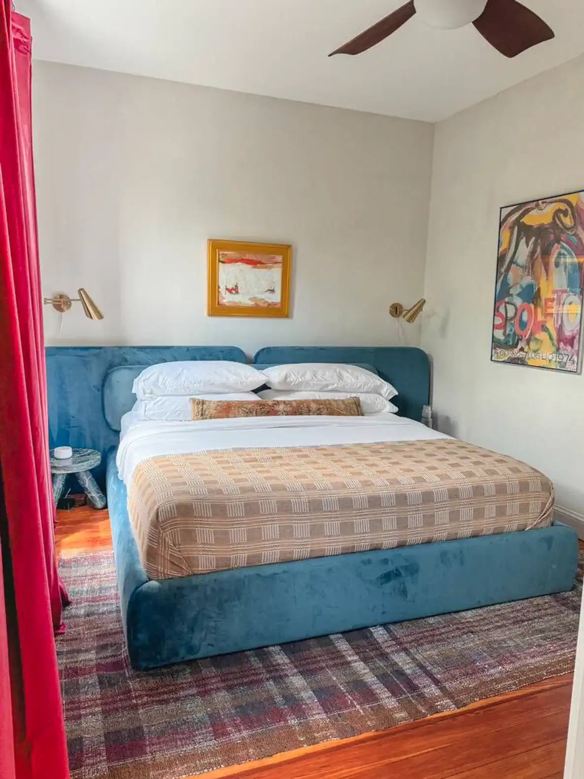 Cozy master bedroom featuring a plush bed with decorative pillows and stylish artwork