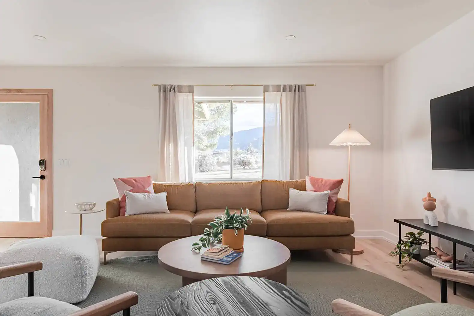 Cozy living room with a sofa, decorative pillows, and a large window offering mountain views