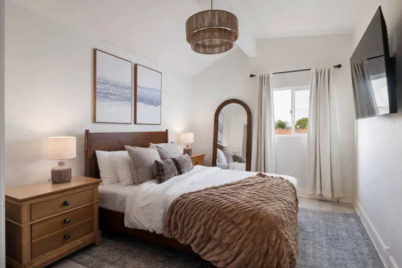Chambre confortable avec un grand miroir, une literie douce et de la lumière naturelle