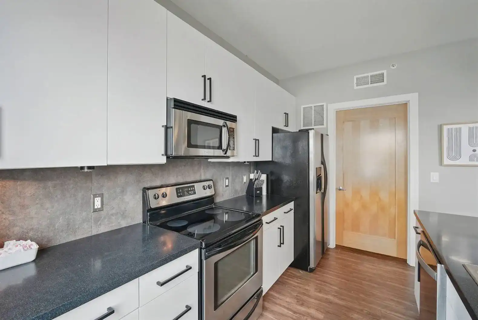 Cook with ease using stainless steel appliances, ample cabinetry, and generous counter space in this contemporary kitchen.