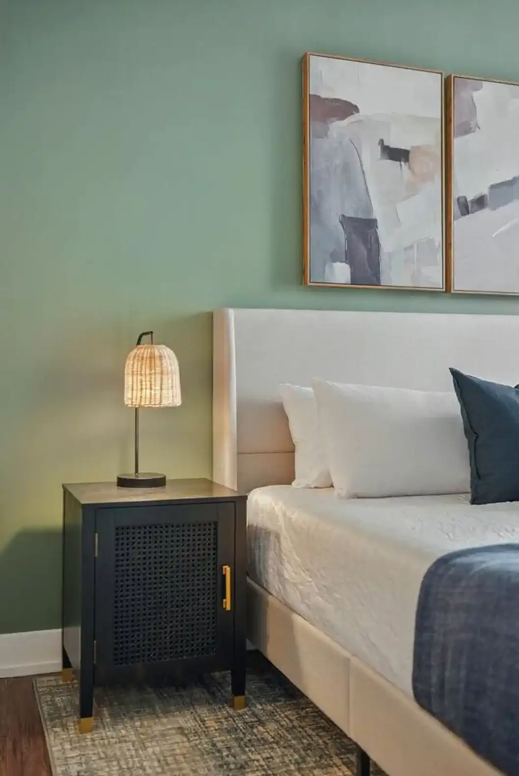Bedside lighting meets stylish design. Enjoy warm rattan lamps, a modern black nightstand with gold accents, and easy access to your nighttime essentials.