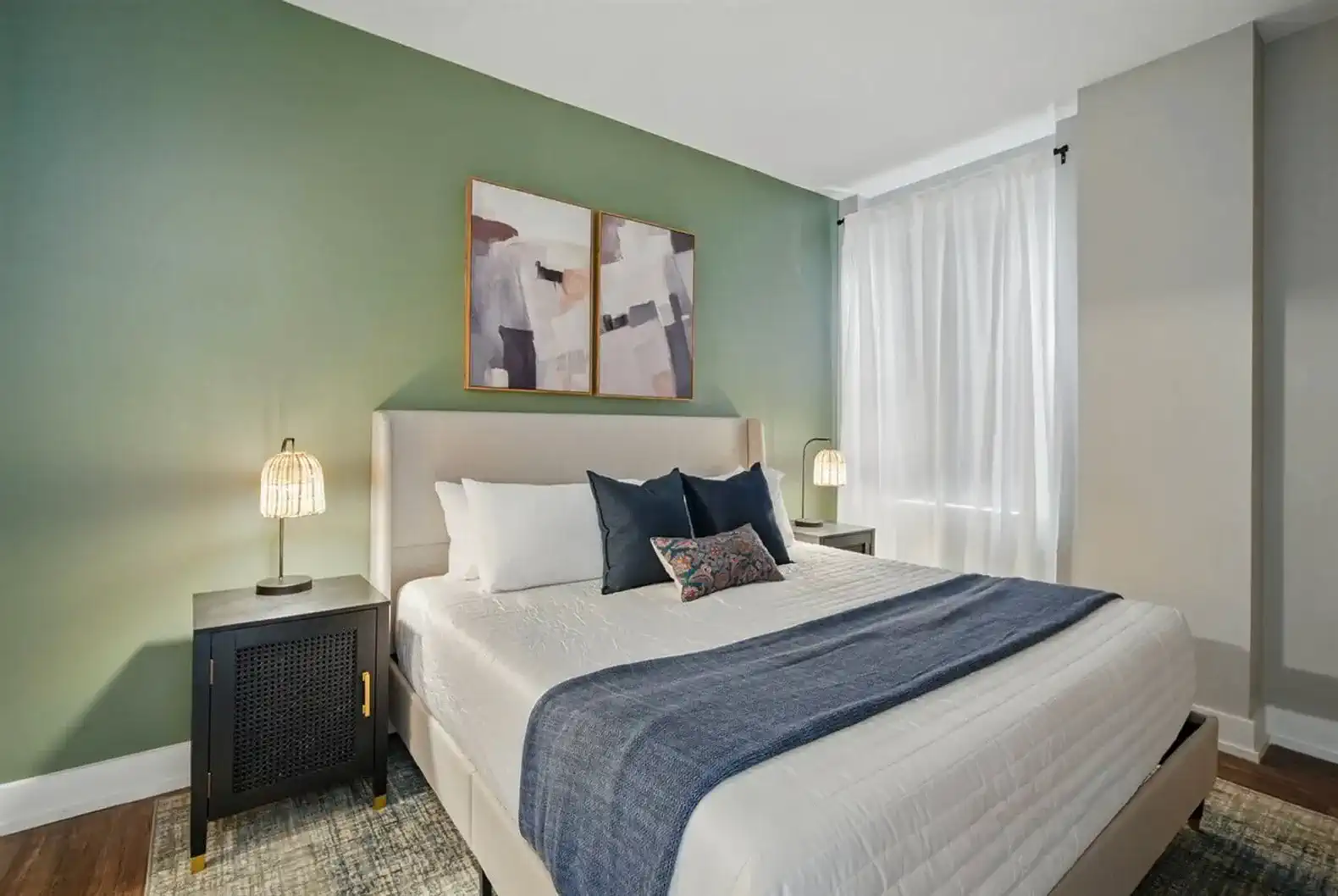 Spacious bedroom with a king-size bed, bold green accent wall, and matching nightstands. Bright, airy, and designed with comfort in mind.